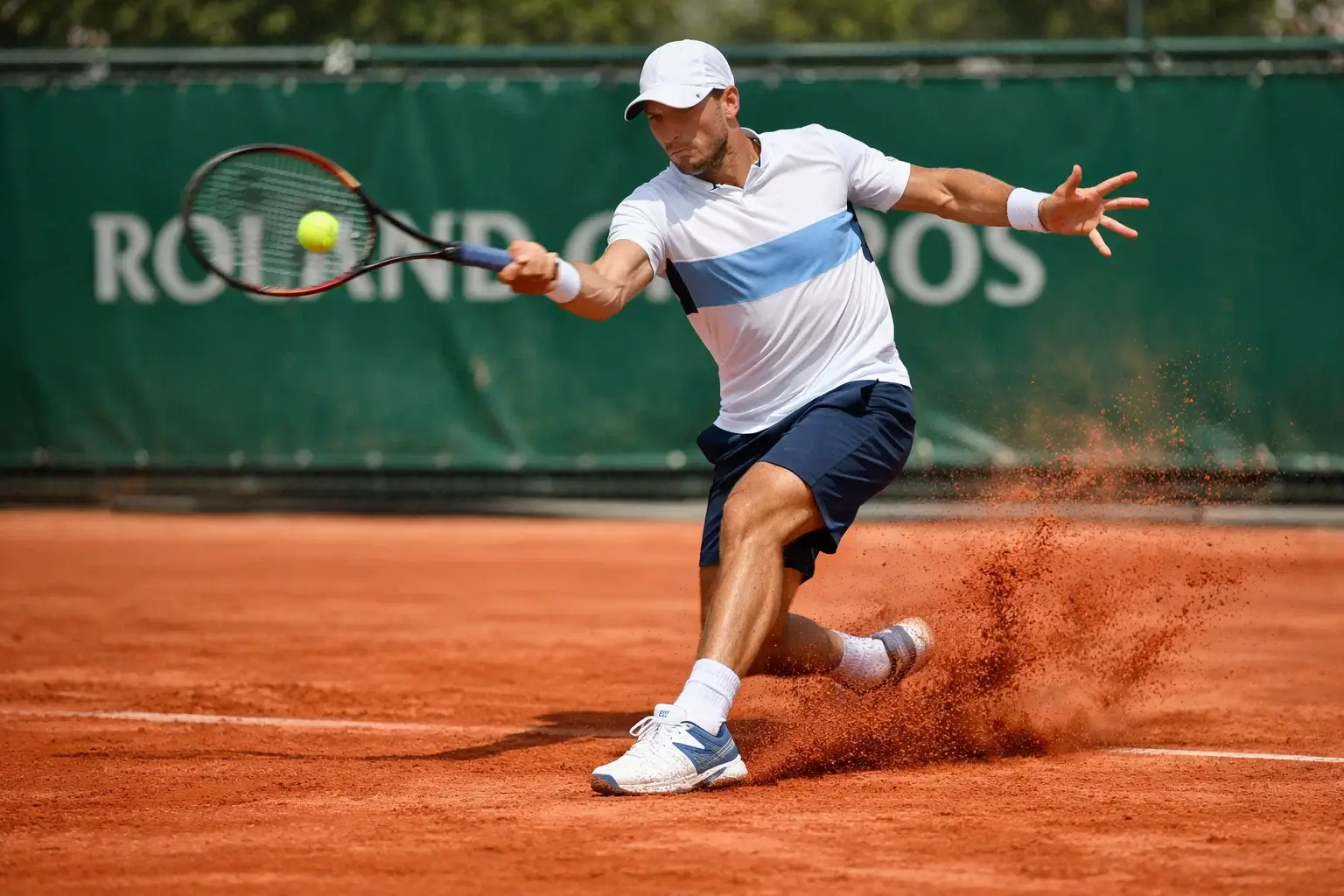 Tennisser slaat forehand op rode gravelbaan tijdens Roland Garros wedstrijd